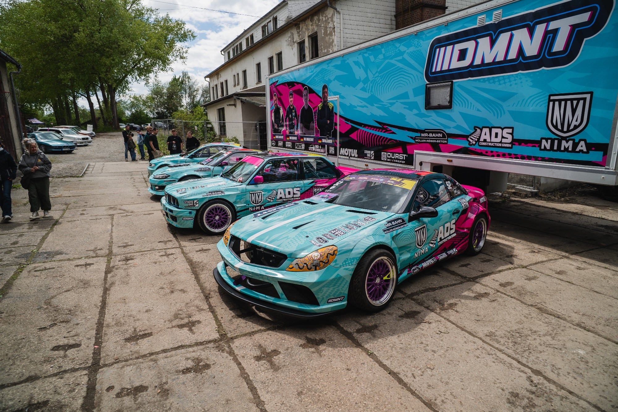 Rennwagen des DMNT-Motorsportteams mit Designfolierung in Türkis und Pink von STUDIO ONE